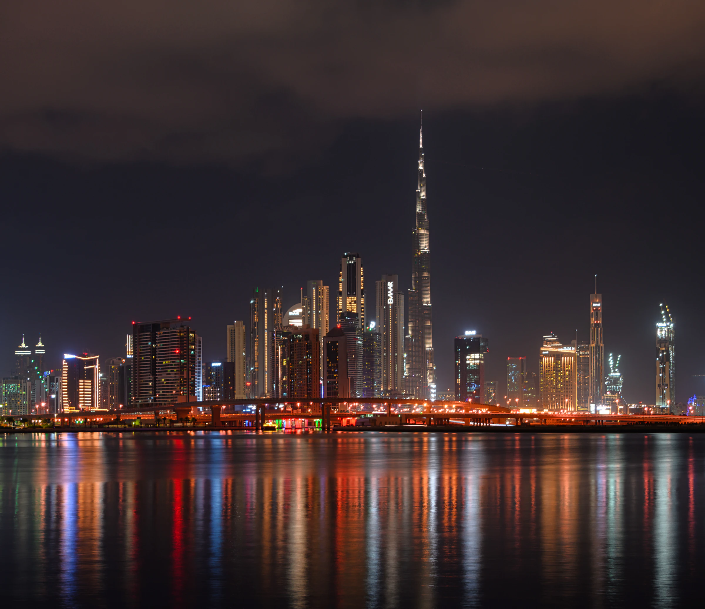 Dubai skyline with Burj Khalifa reflected in the water at night