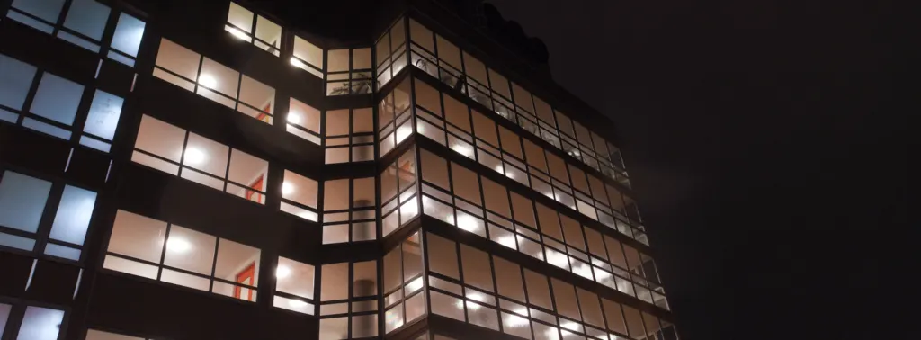 Modern commercial building with illuminated floors at night