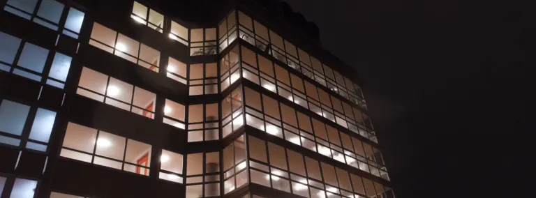 Modern commercial building with illuminated floors at night