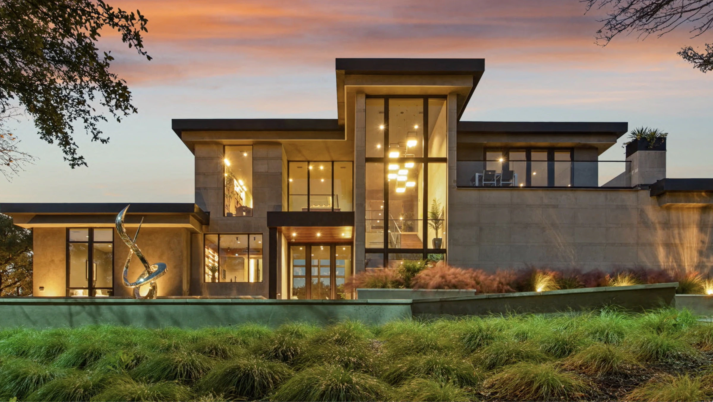 Modern luxury residence with large windows lit at dusk